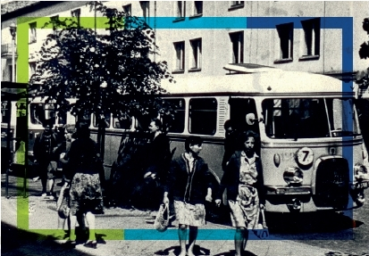 Zdjęcie archiwalne. Widok na przystanek i stojący na nim powojenny autobus. Trwa wymiana pasażerów.
